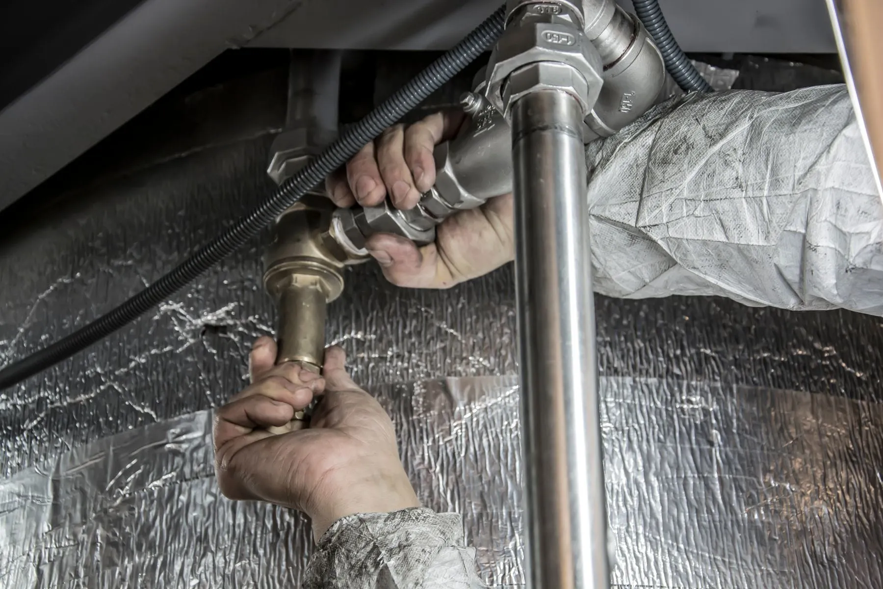 Plumber tightening a pipe fitting during a repair
